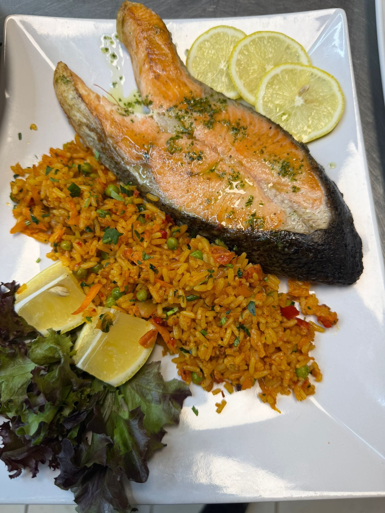 Grilled salmon steak with vegetable rice and salad at Restaurant Acasă