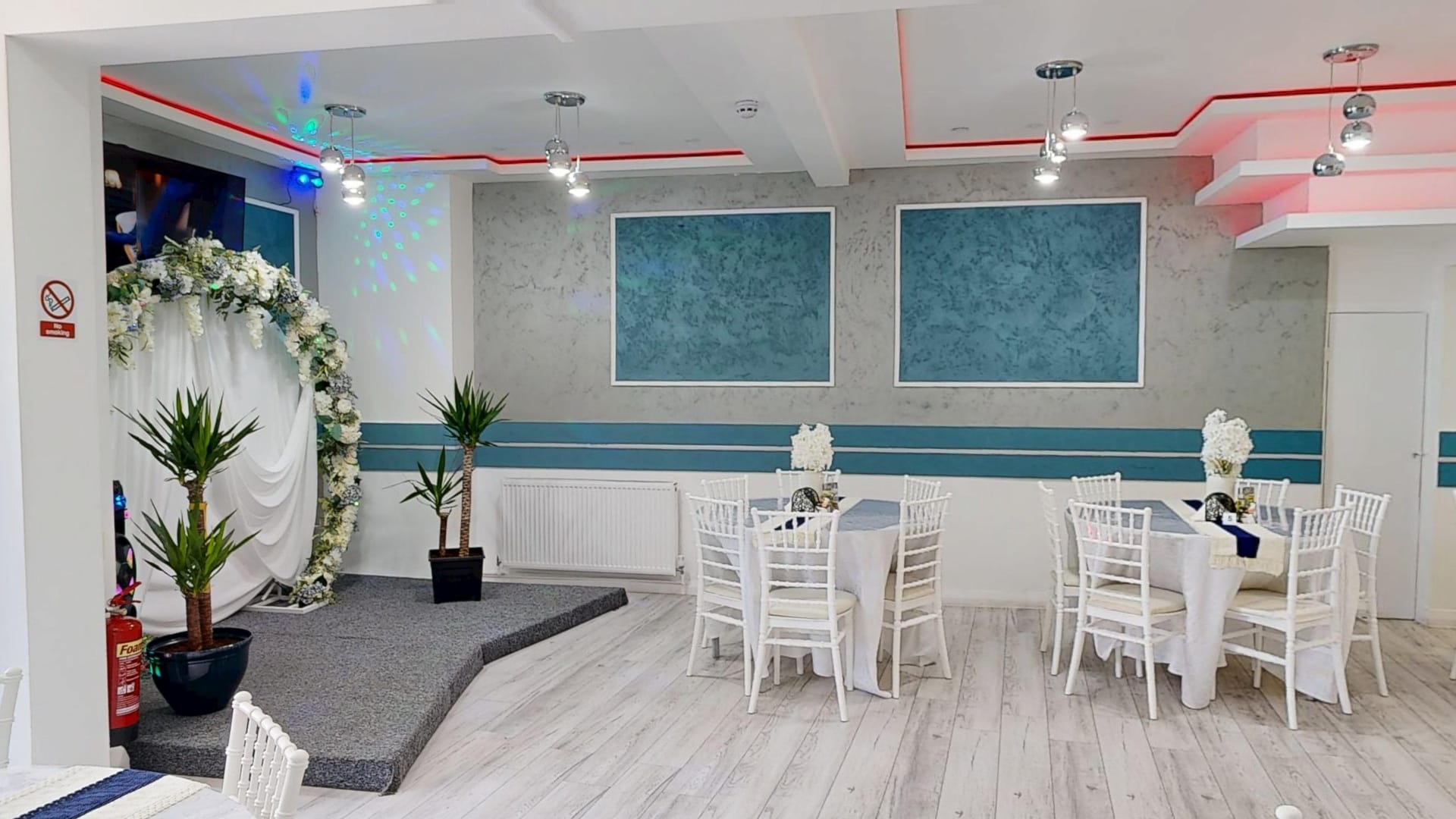 Events room at Restaurant Acasă set for a party, with the floral arch and dressed tables